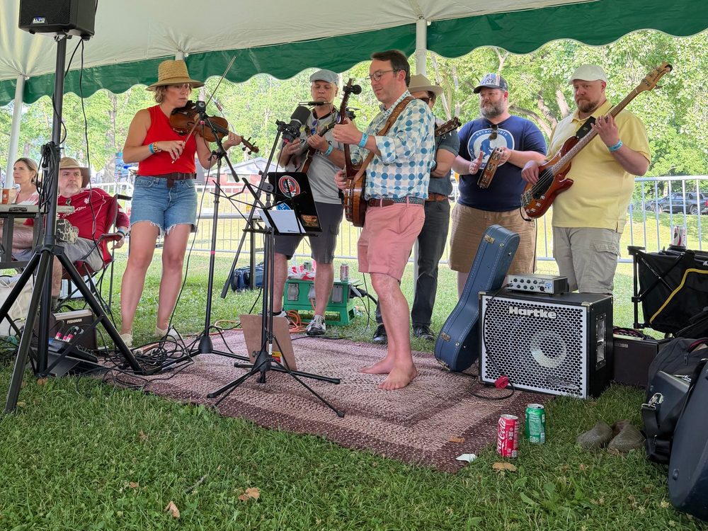Heart Fjord playing under a green and white tent at the Hudson River Music Festival
